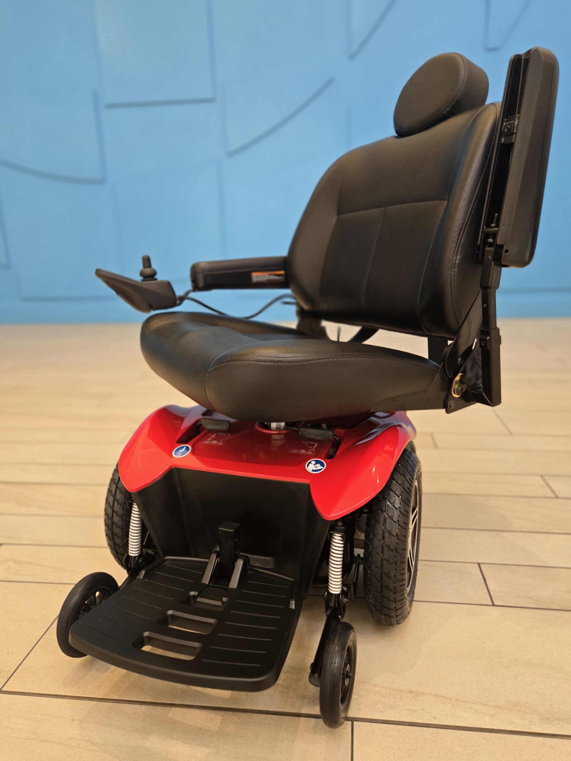 Red Pride Jazzy Select HD power chair with black captain’s seat, new batteries, and front footrest.