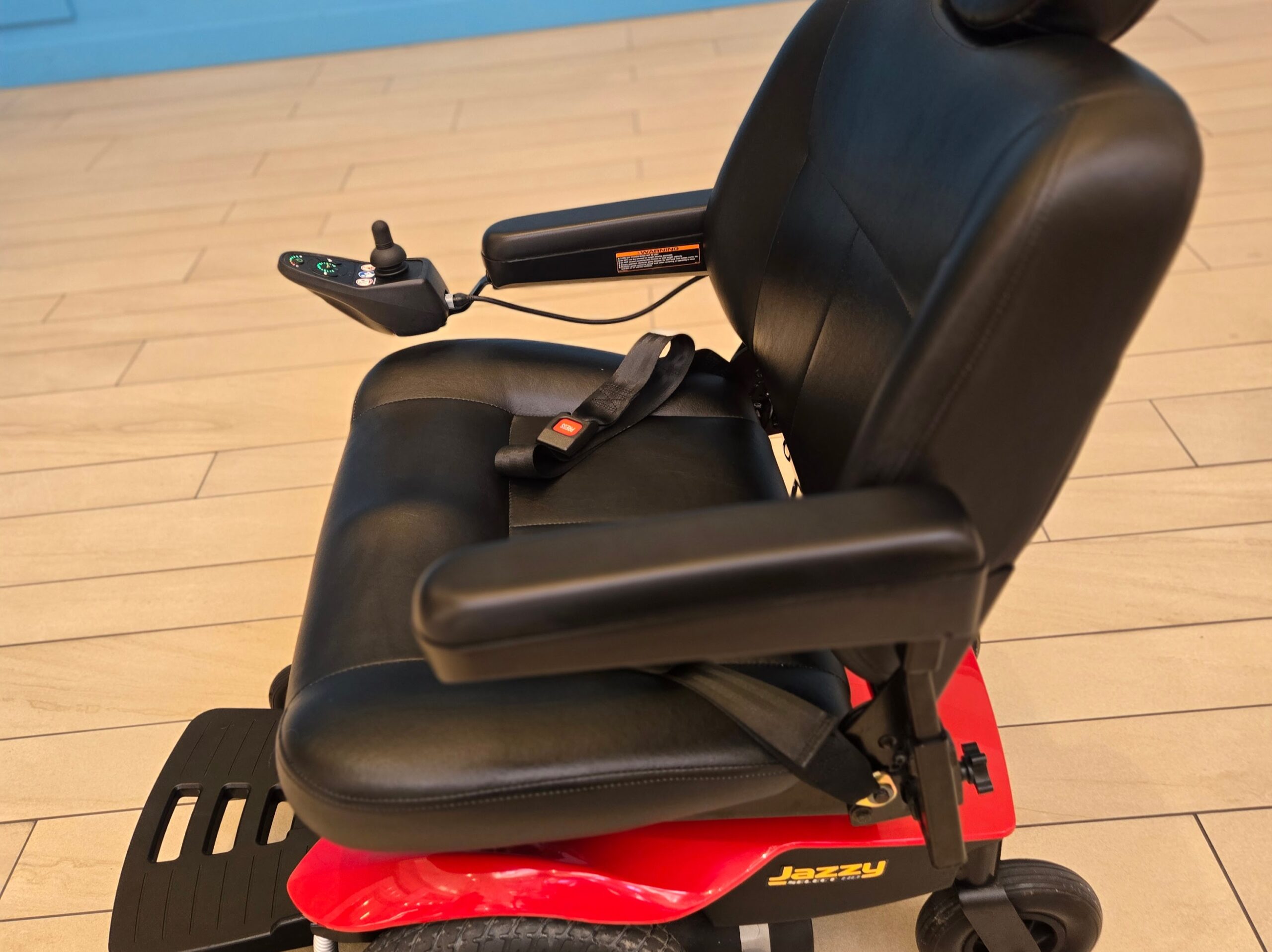 Red Pride Jazzy Select HD power chair with black captain’s seat, new batteries, and front footrest